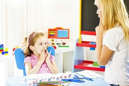 speech therapist working with young girl