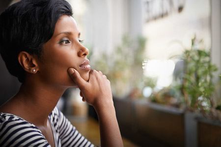 woman looking out window contemplating