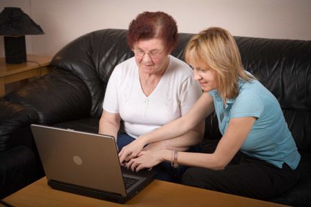 social worker on laptop with elderly client