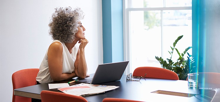 woman sitting at desk looking out window