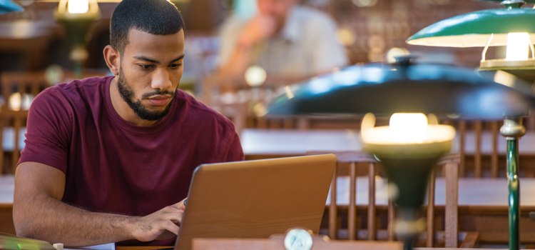 african american male student studying for his bachelor's in psychology in his university library