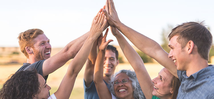 group of diverse people high fiving each other