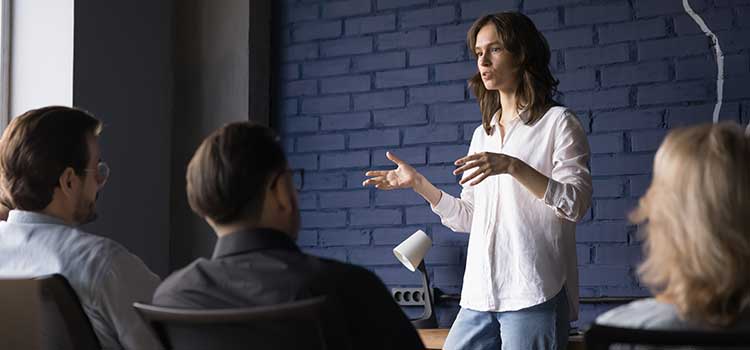 woman leads group of adults in life coach session