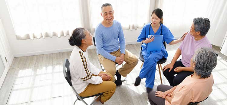 nurse works with group of four senior patients