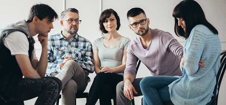 emotional group session with other members comforting one participant