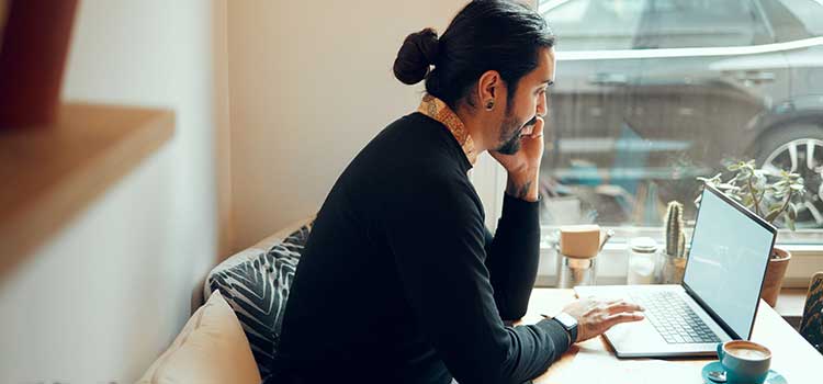 psychology doctoral candidate sits at his office desk and works online