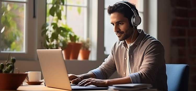 man with headphones studying on laptop