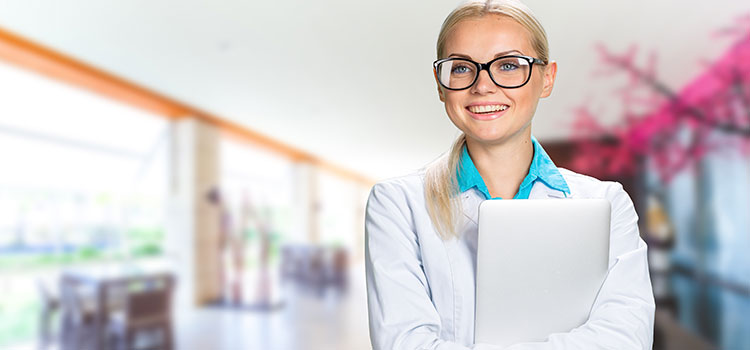 psychology professional holding laptop in office hallway