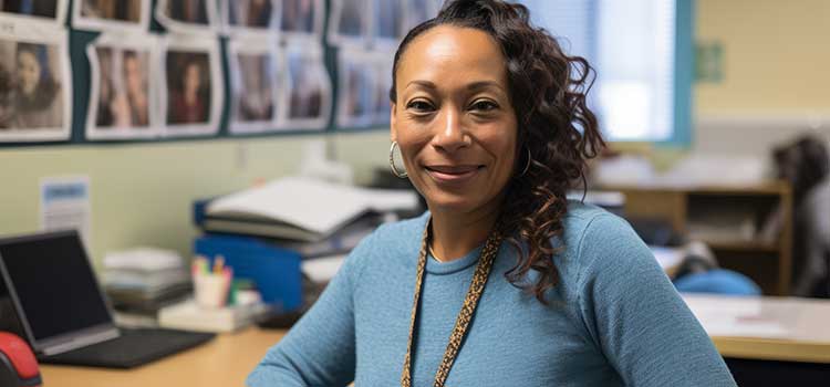 woman in busy correctional office smiling and facing camera