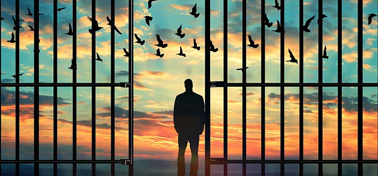 man steps through prison bars after working with prison psychologist