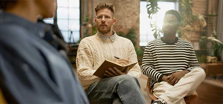 substance abuse counselor takes notes in a florida mens group meeting