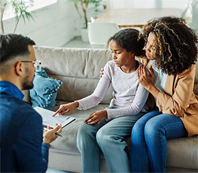 therapist listens to mom and daughter during a family session