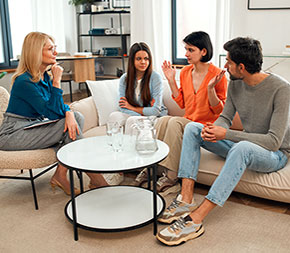 marriage and family therapist listens to woman talk about family as her daughter and husband listen