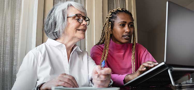 human services case manager helps elderly woman find resources online