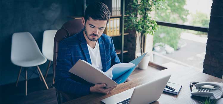 human services case manager sits at desk and reviews client file