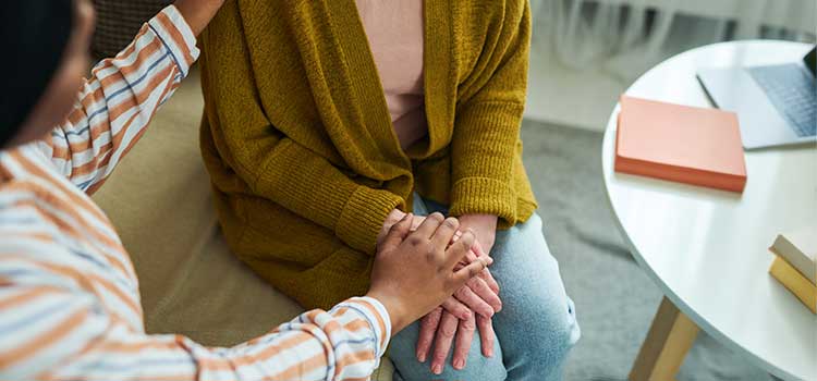 a human services worker puts a gentle hand on their client