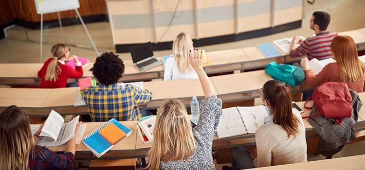 a human services student raises her hand in a college classroom